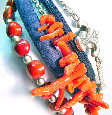 6) Fire coral next to coconut kernels, placed between suede and lizard skin. Ornaments made of solid sterling silver.